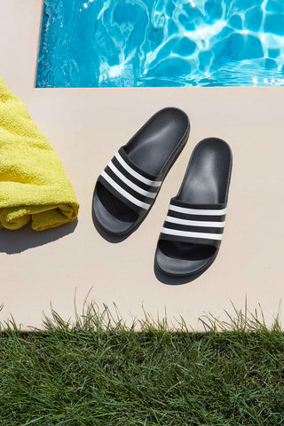 Schwarze Badeschuhe mit Adidas-Streifen Adilette Aqua